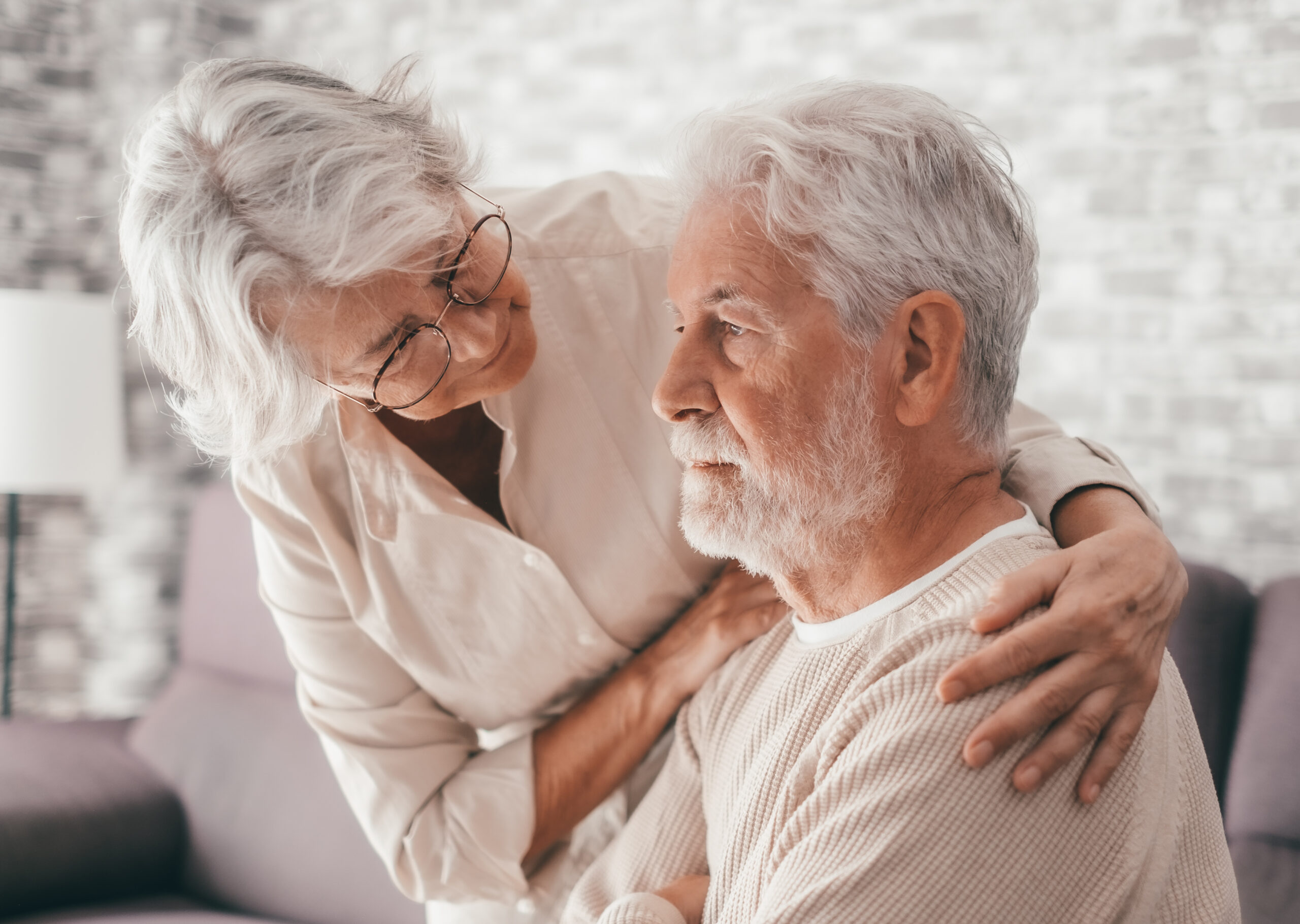 A woman comforting her husband with dementia